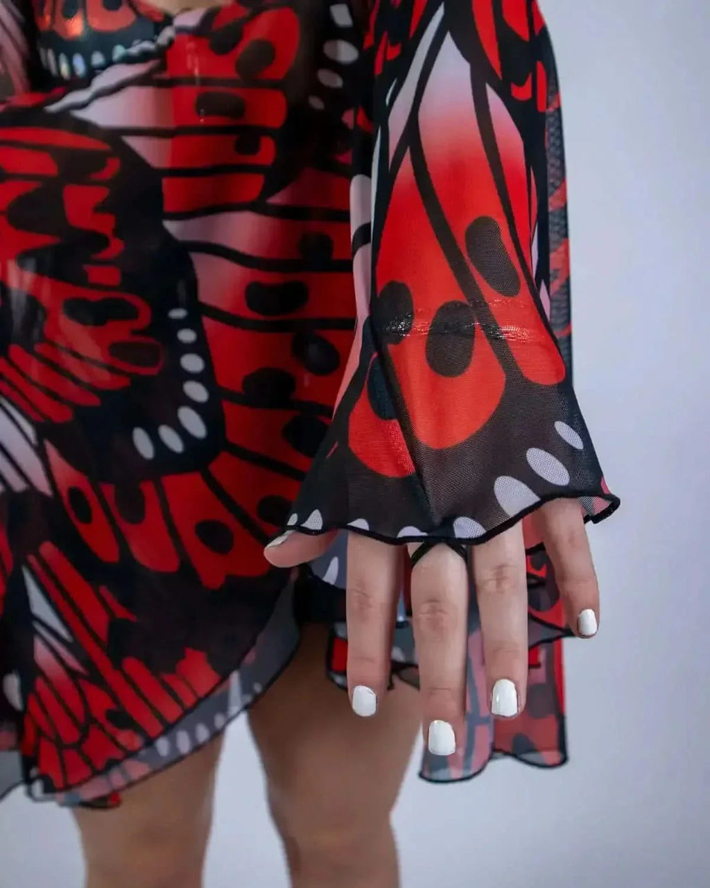 Lacewing rave arm sleeves detail showing red black butterfly wing pattern mesh bell cuffs on model's hands