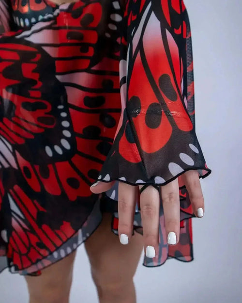 Lacewing rave arm sleeves detail showing red black butterfly wing pattern mesh bell cuffs on model's hands