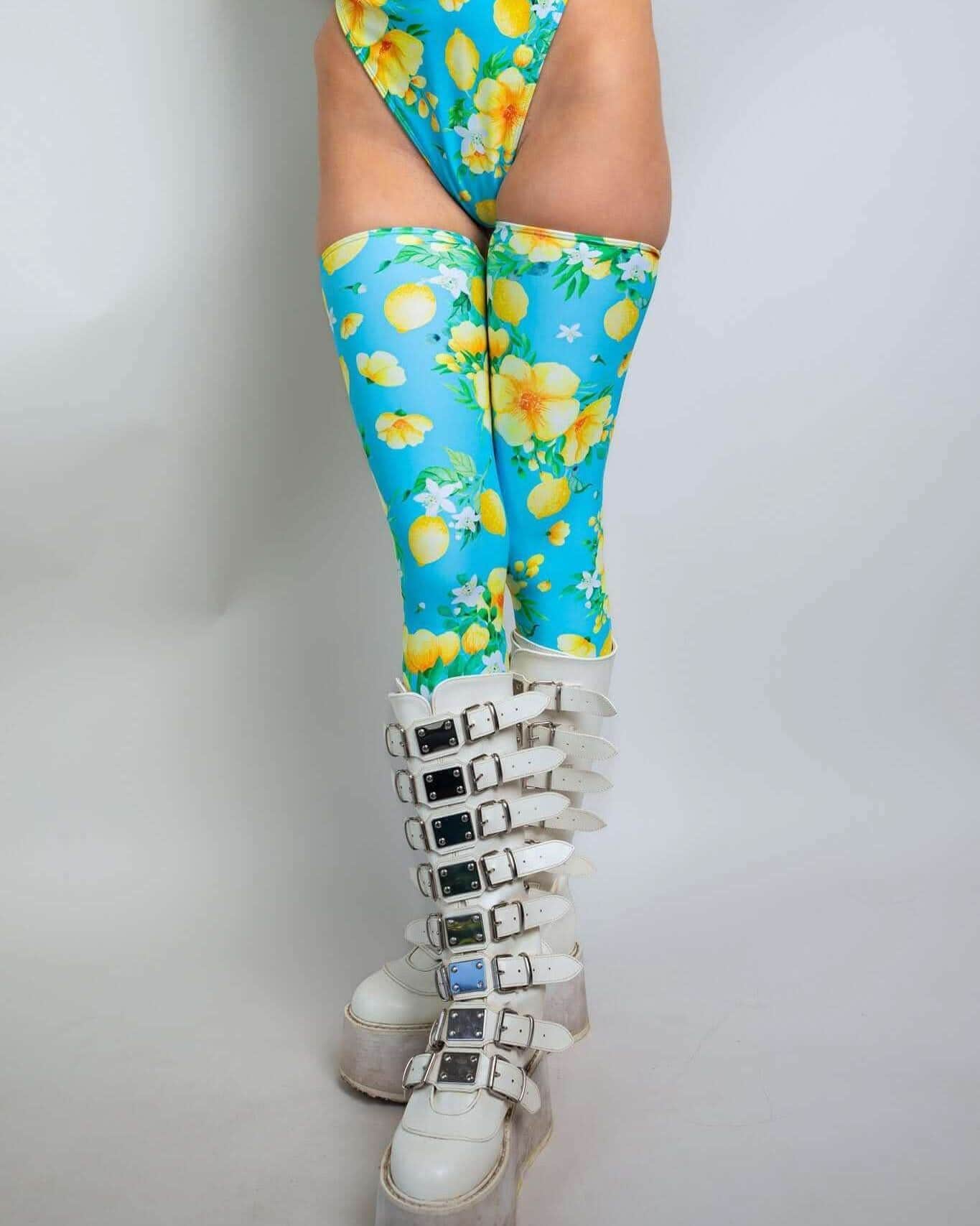 Rave arm sleeves in Lemon Drop print - vibrant blue tropical festival leg sleeves with crossed legs pose