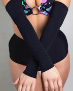 Model wearing matte black rave arm sleeves crossed over torso with galaxy print festival outfit