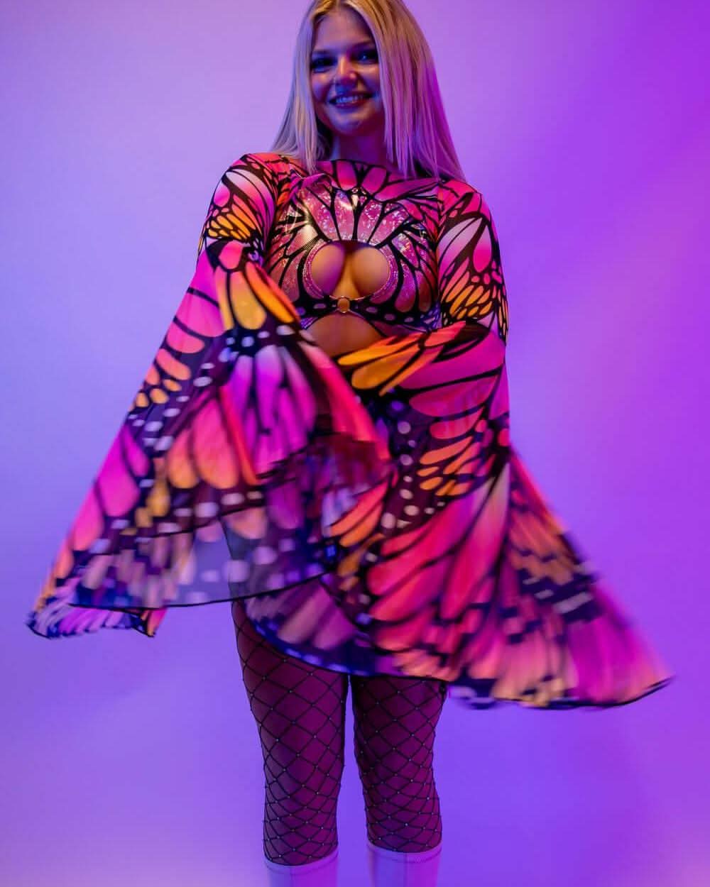 Model dancing in Monarch butterfly rave arm sleeves with flowing bell design at festival