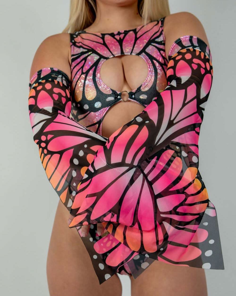 Pink Monarch Metamorphosis rave arm sleeves with butterfly wings pattern on festival outfit model front view