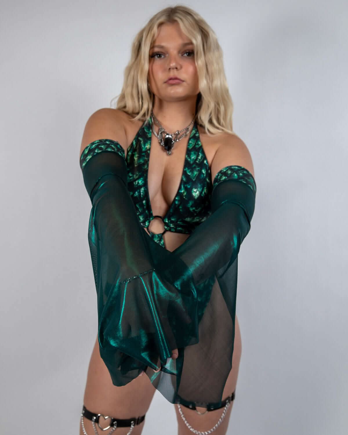 Blonde model wearing emerald Predator Metamorphosis rave arm sleeves with sequined halter top front view