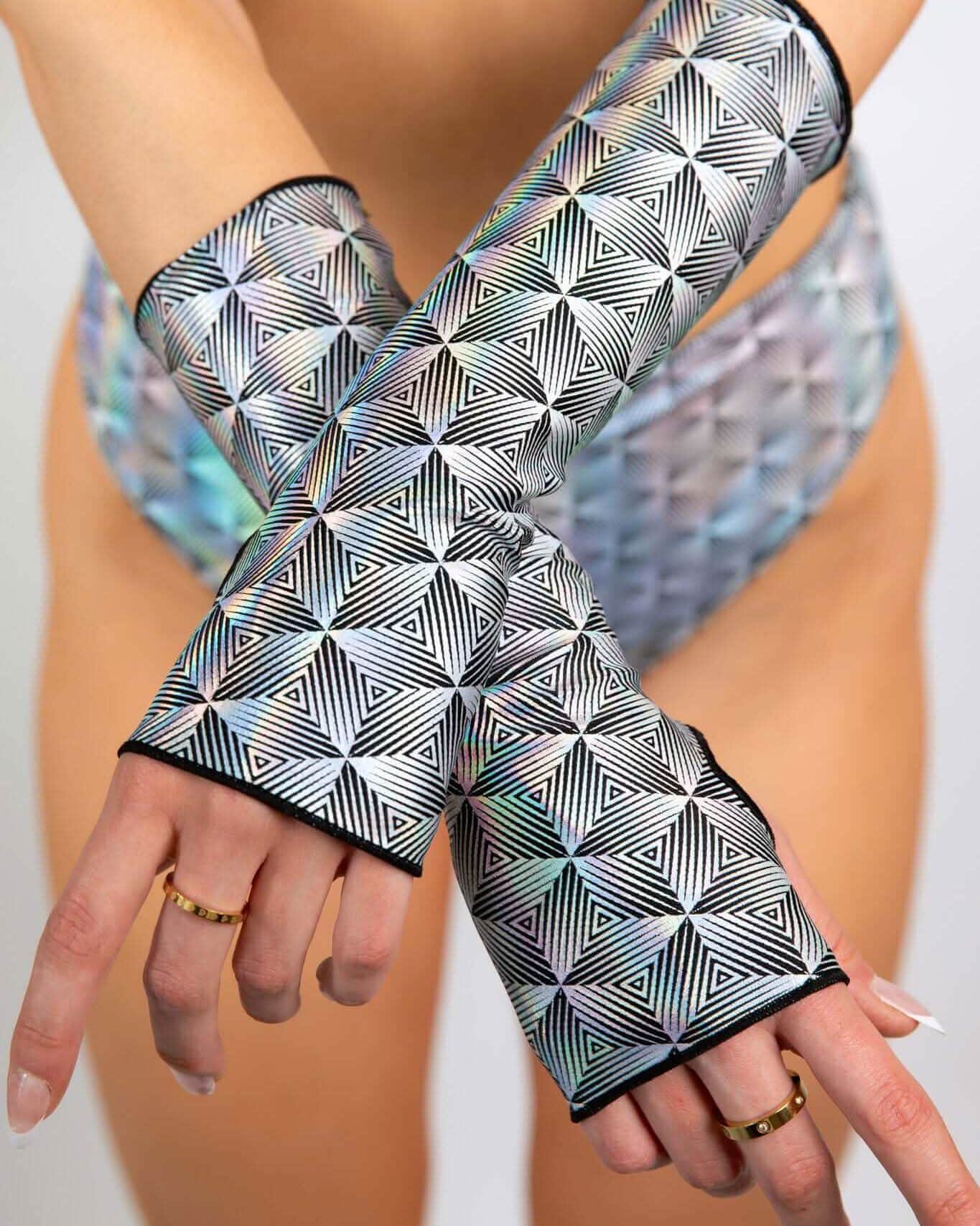 Prism rave arm sleeves with holographic geometric pattern modeled in crossed arms pose for festival outfit styling