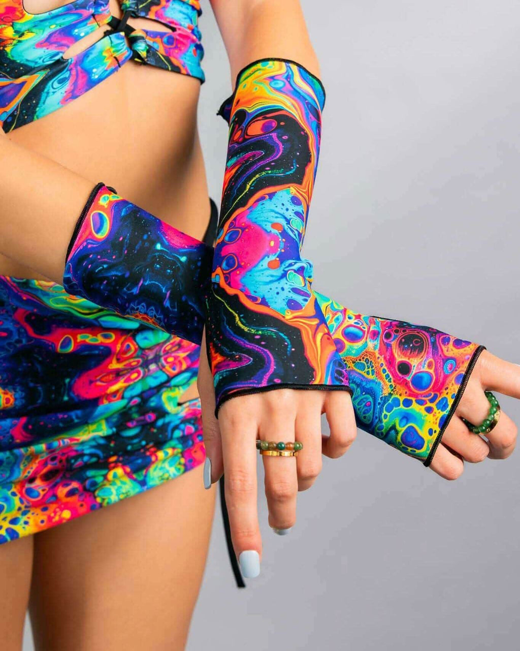 Colorful psychedelic rave arm sleeves with fingerless design in vibrant Tripping in Technicolor swirl pattern for festival outfit