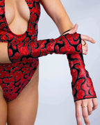 Red Inferno rave arm sleeves with black flame pattern modeled with matching bodysuit for festival outfit