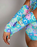 Rave arm sleeves in Retro Bloom floral print with decorative slits, festival fashion detail shot