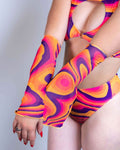 Model wearing Tangerine Tango psychedelic swirl rave arm sleeves in orange pink purple festival outfit styling