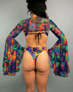 Back view of Vivid psychedelic rave arm sleeves with dramatic bell shape and matching festival outfit bottom