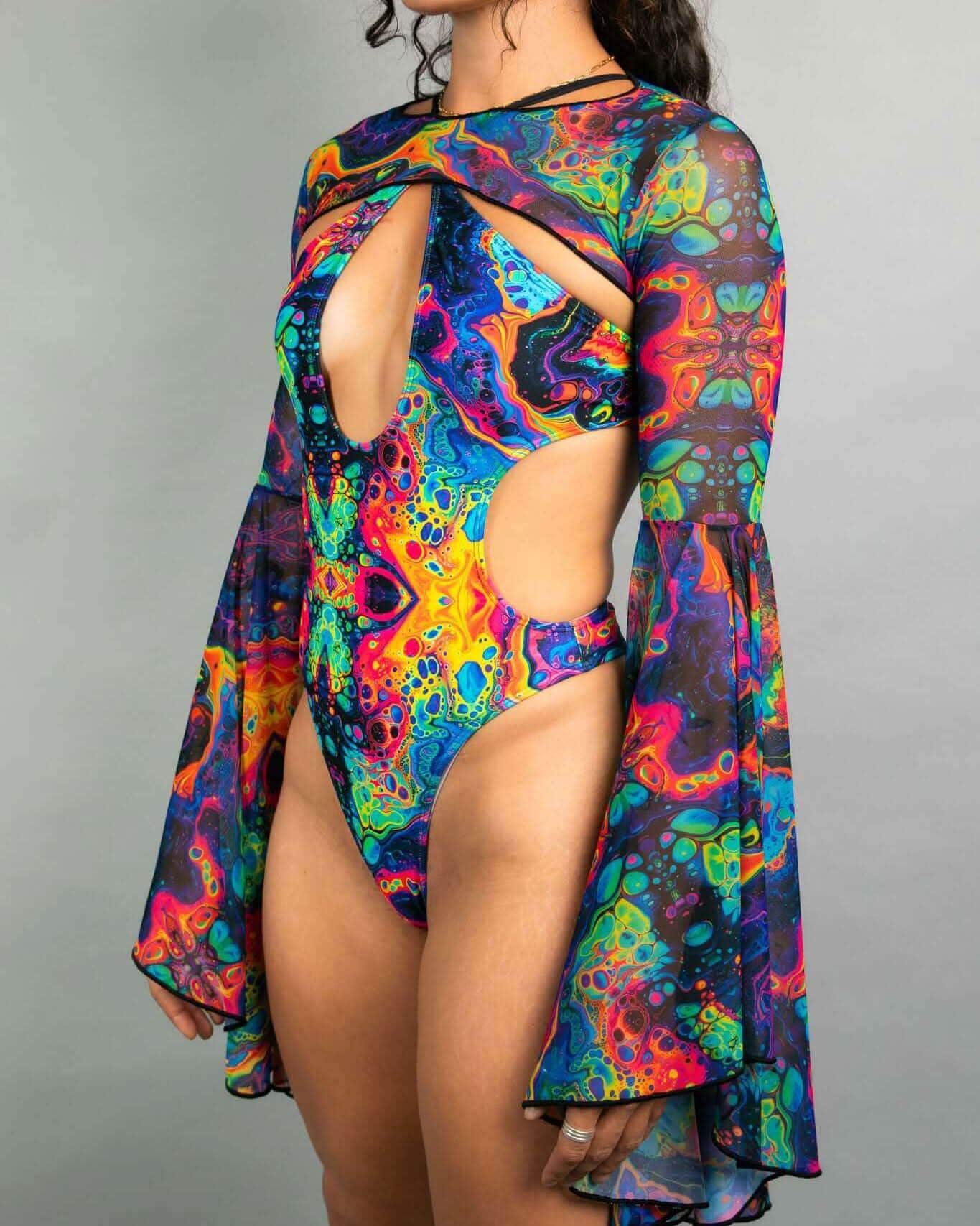 Model wearing Vivid mesh rave arm sleeves with rainbow tie-dye pattern and dramatic bell shape, front view