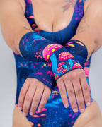 Model displaying Wildwood rave arm sleeves with colorful mushroom print in crossed wrist pose for festival outfit styling