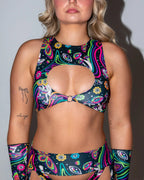 Awaken Keyhole Top in a vibrant psychedelic print with eyes, mushrooms, and wavy lines, front view on a model