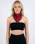 Amplitude Bandana front view, a red and black rave bandana with geometric and psychedelic patterns, worn by a woman.
