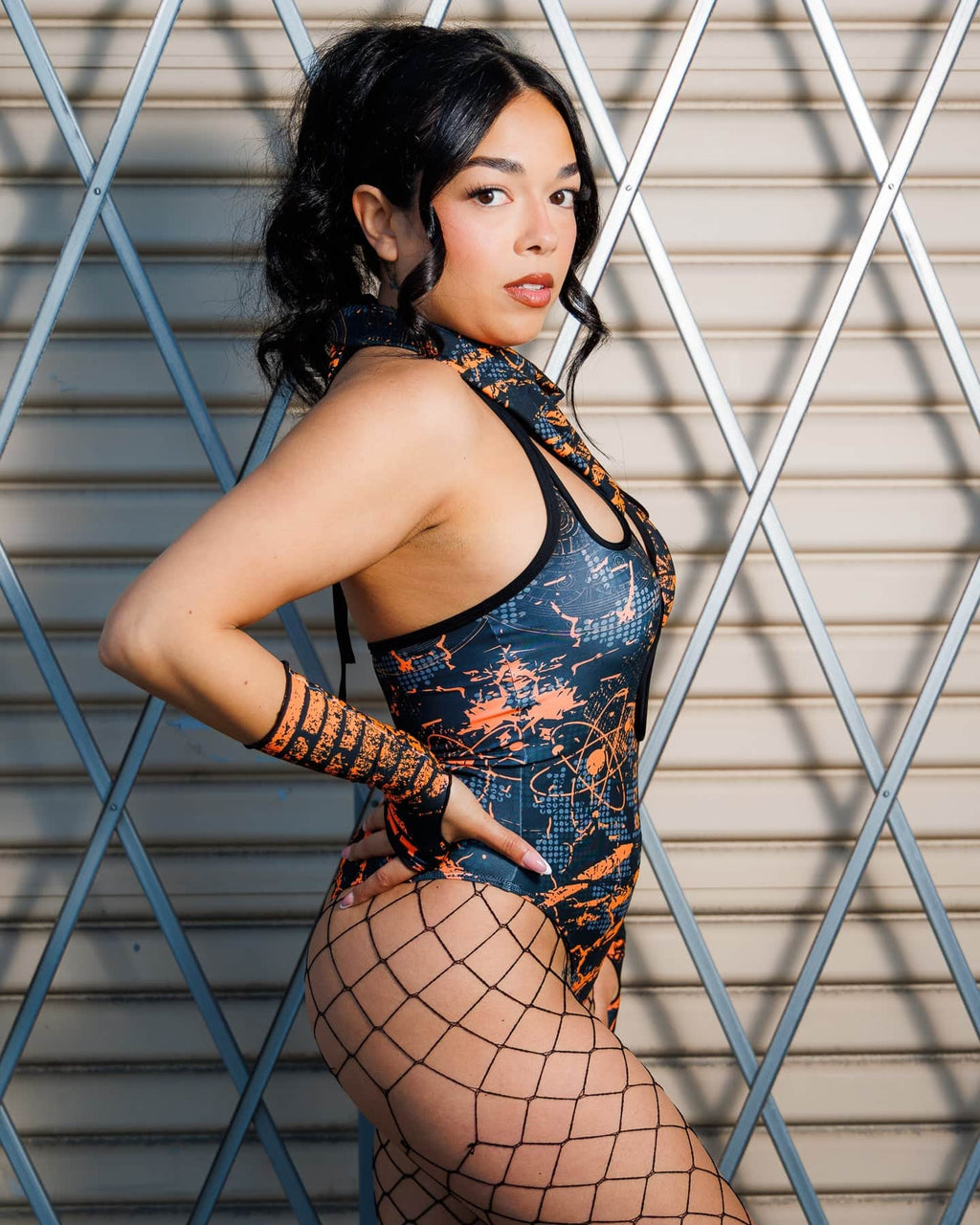 Model wearing the Atomic Bandana as a necktie, featuring neon orange splatters and distressed blue-grey geometrics, for a festival look.