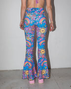Groovy Bell Bottoms from the back, featuring a vibrant blue and purple psychedelic rave pattern with smiley faces and rainbows.