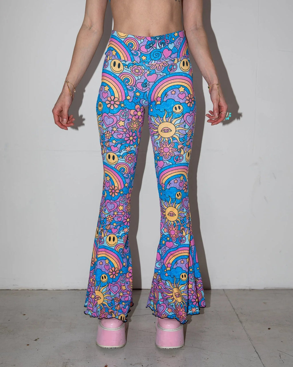 Groovy Bell Bottoms in a psychedelic pattern featuring smiley faces and rainbows, perfect for rave festivals