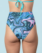 Glacial High Waisted Bikini Bottoms from the back, featuring a unique blue, teal, and lilac marbled rave pattern.