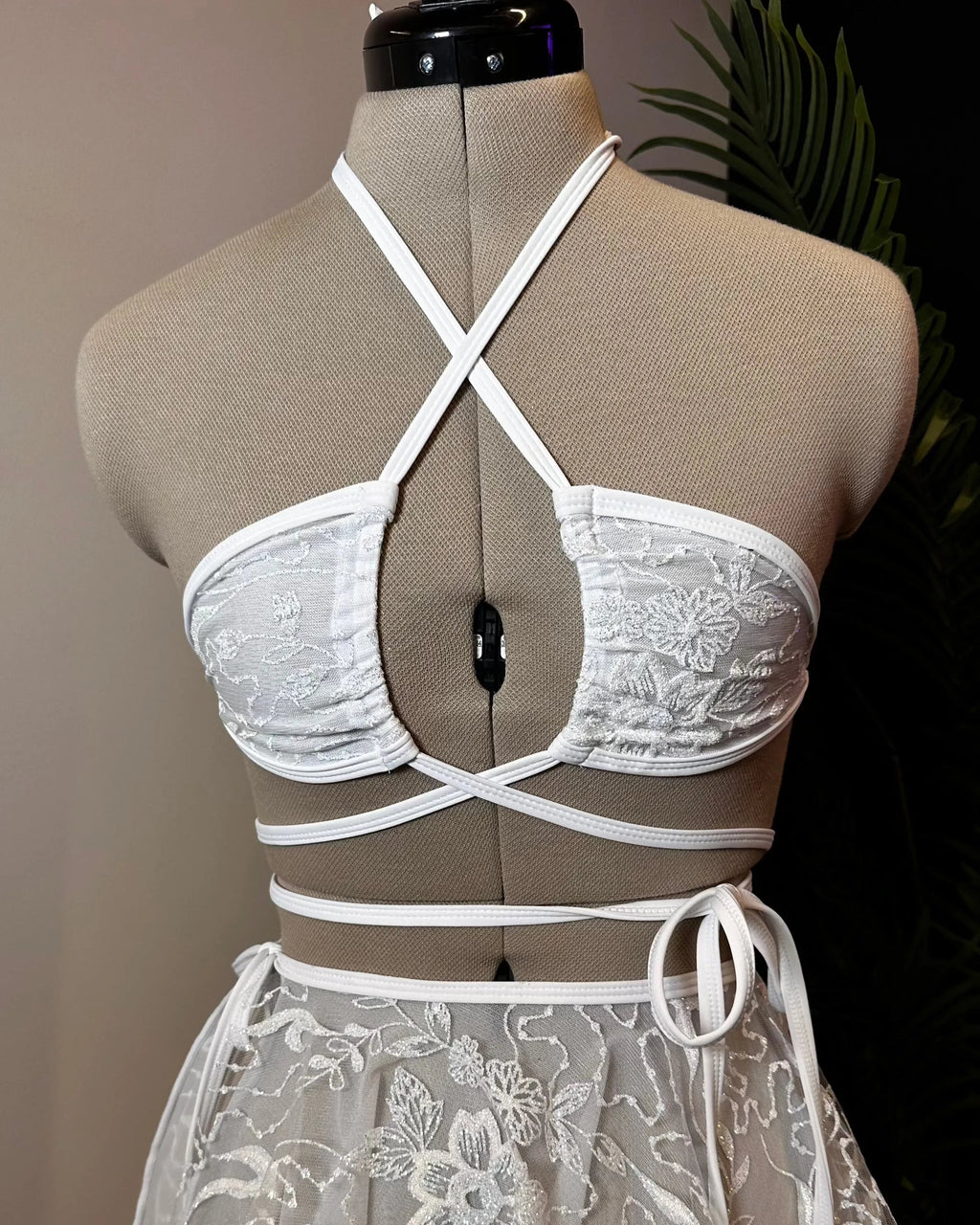 Seraphina Wrap Bikini Top in white lace with floral pattern on a mannequin, perfect for a festival rave look.