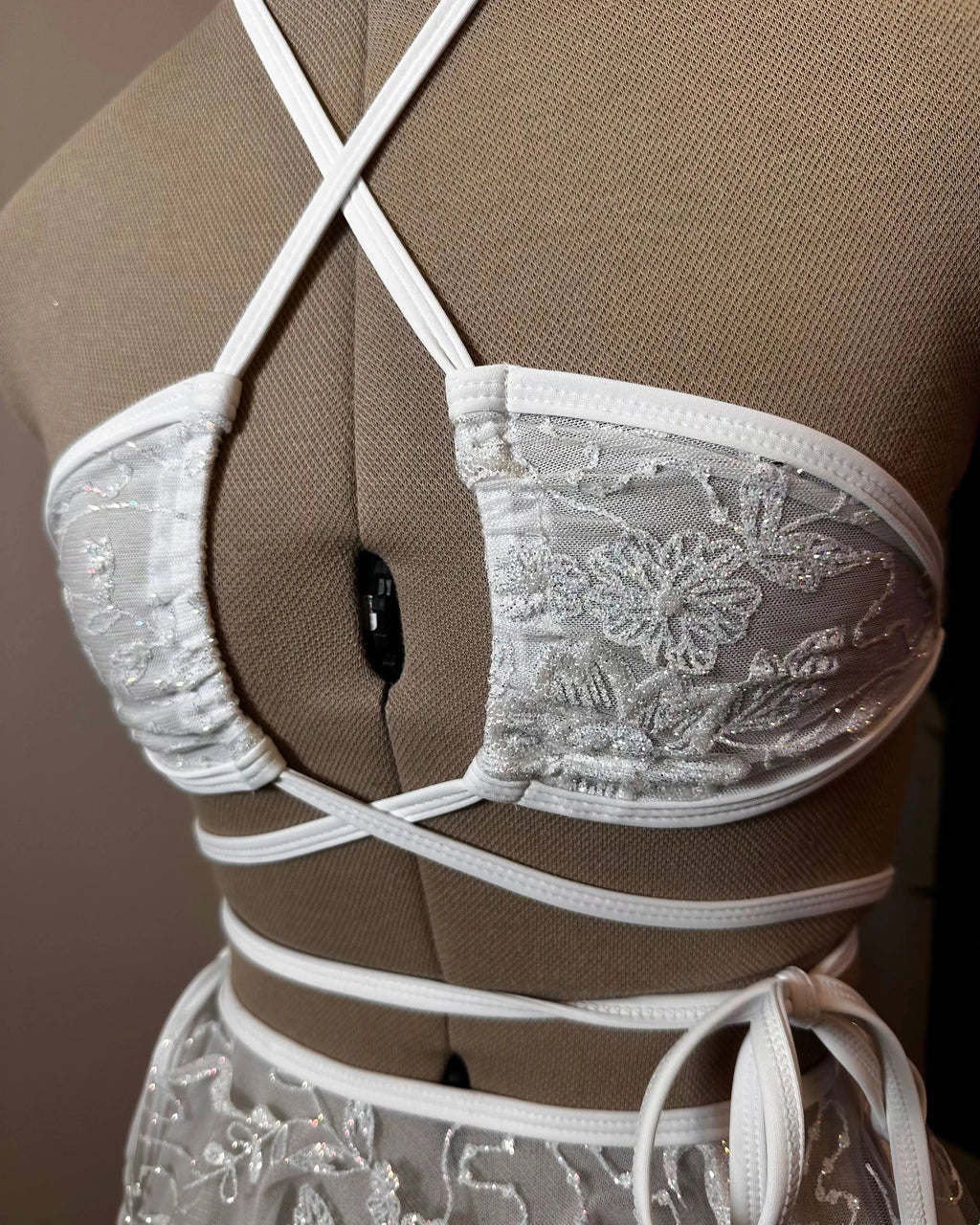 Seraphina Wrap Bikini Top in white glittery lace, shown on a mannequin from the front, perfect for rave festivals.