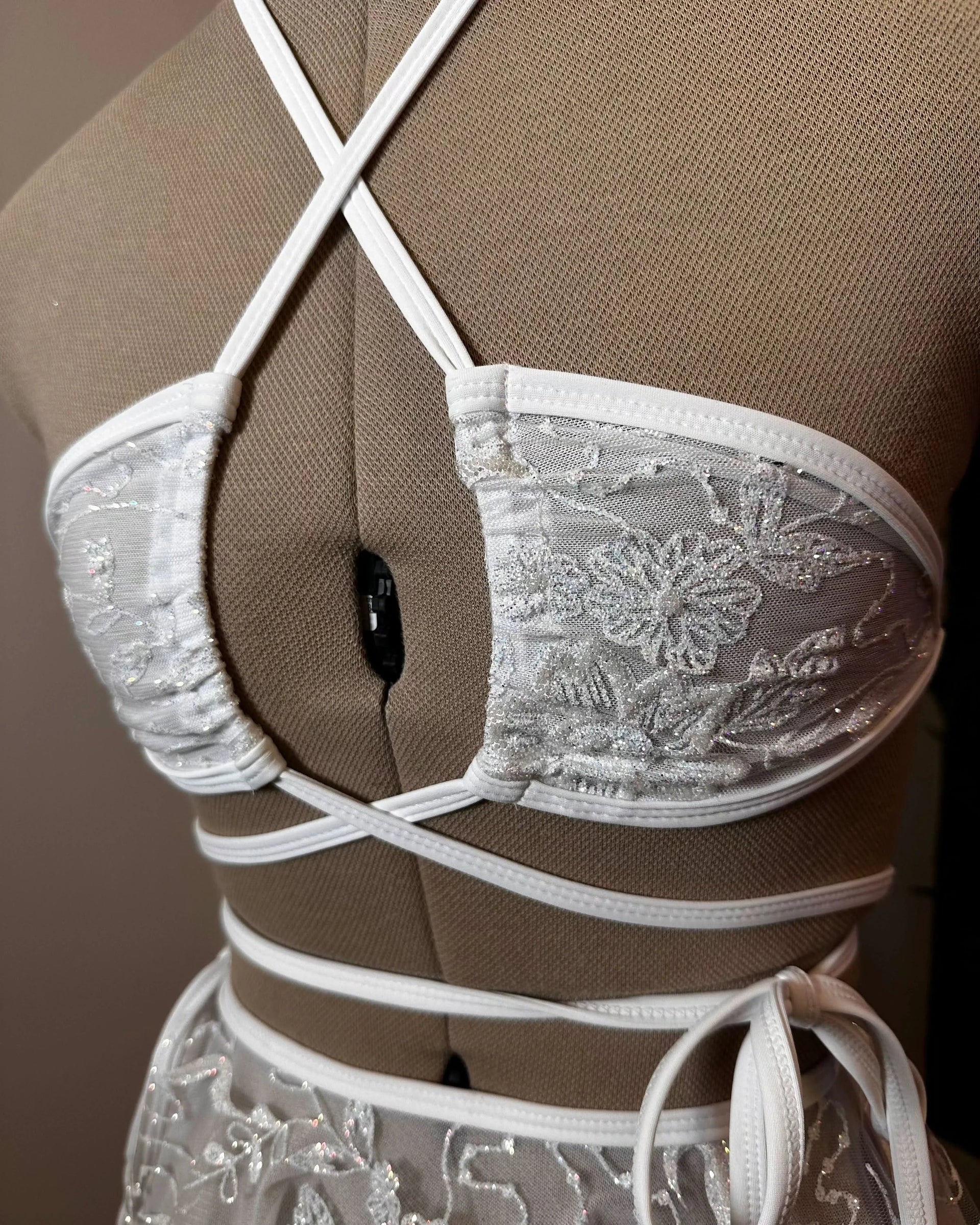 Seraphina Wrap Bikini Top in white glittery lace, shown on a mannequin from the front, perfect for rave festivals.