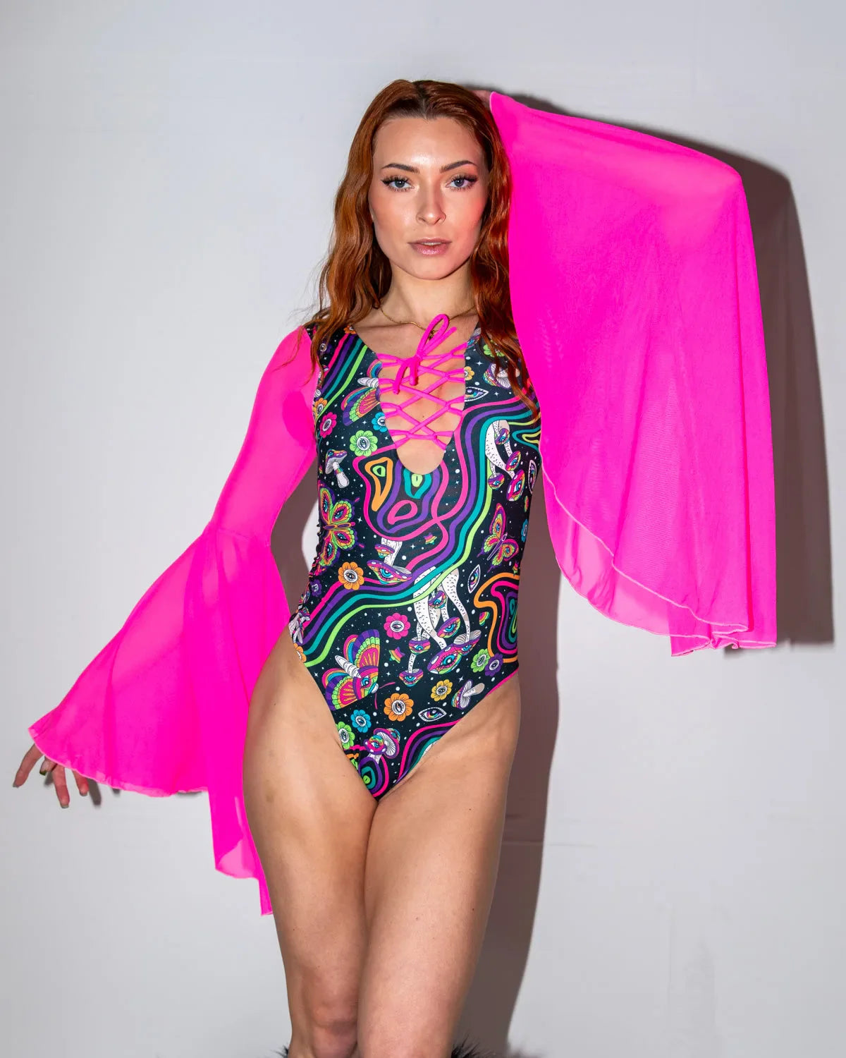 Awaken Goddess Bodysuit front view, featuring a vibrant psychedelic pattern and sheer neon pink bell sleeves, perfect for rave festivals.