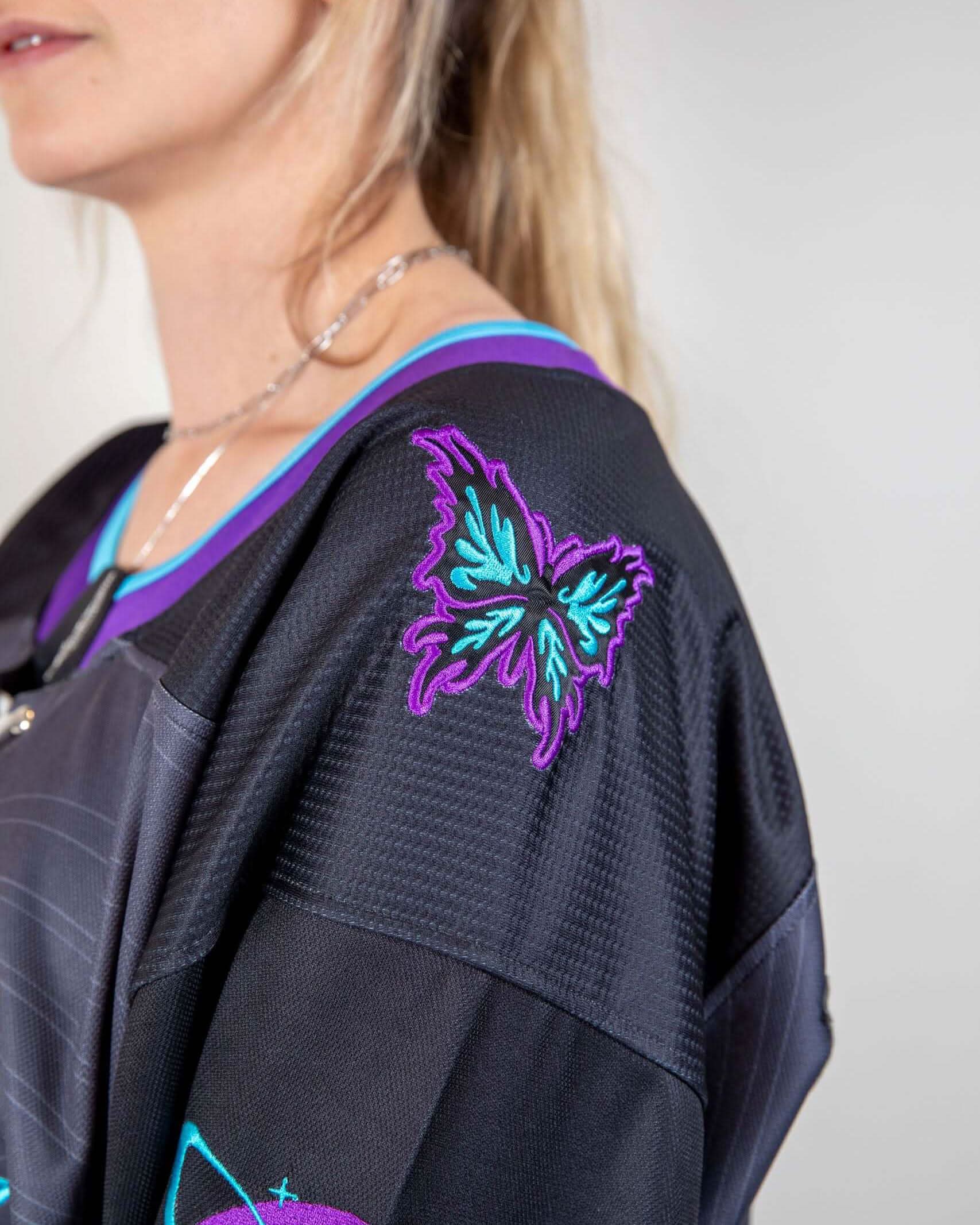 Black rave bodysuit style hockey jersey with purple teal embroidered floral shoulder detail festival outfit