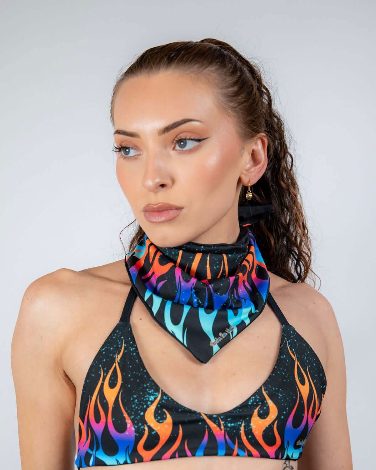 Woman styling rave bodysuit coordinated Blaze bandana with colorful flame pattern around neck