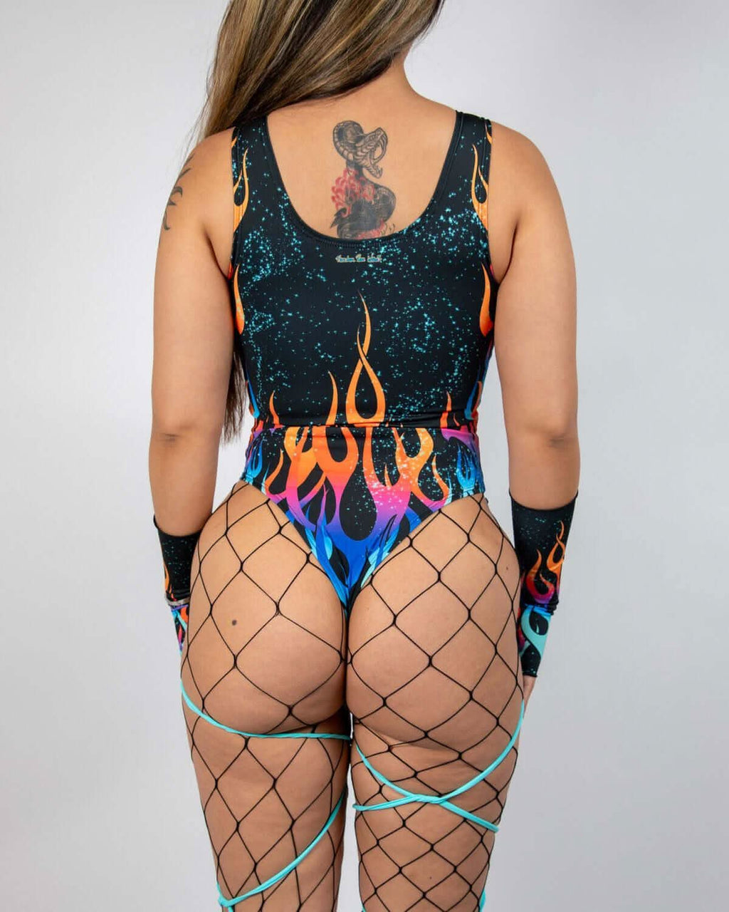 Back view of Blaze rave bodysuit with colorful flame pattern and galaxy speckled design on model
