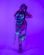 Cross Faded rave bodysuit with skull print and matching leg warmers under purple blacklight