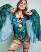 Rave bodysuit in teal Faewood print with lace-up front and flowing bell sleeves for festival fashion