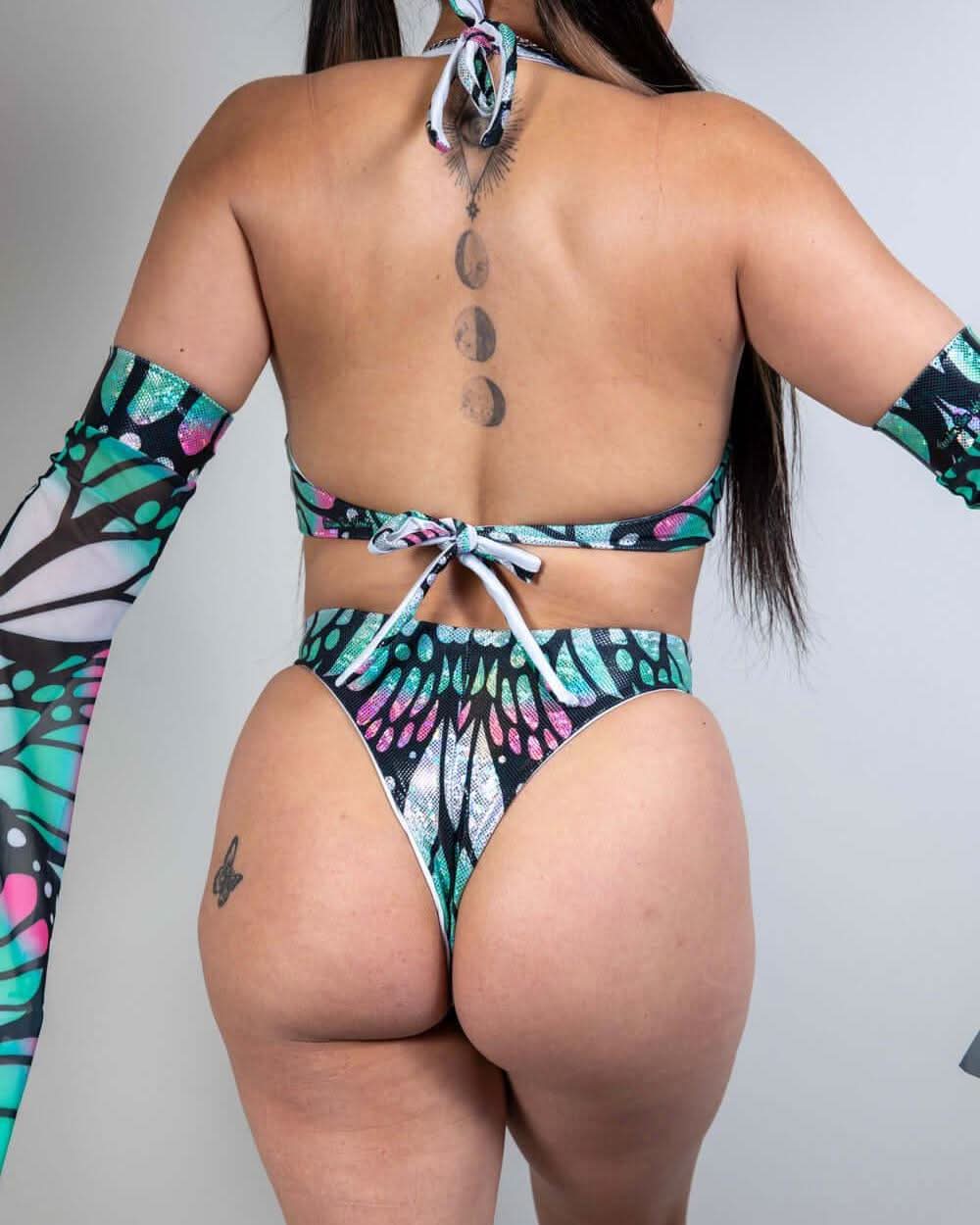 Back view of Flutter rave bodysuit with holographic butterfly print in teal and pink colors