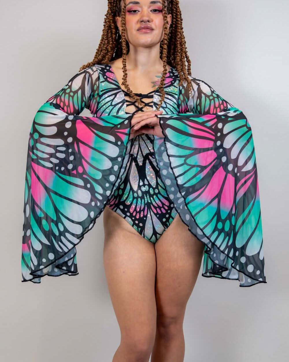 Model wearing Flutter Goddess rave bodysuit with butterfly wing pattern and flowing bell sleeves in lifestyle pose
