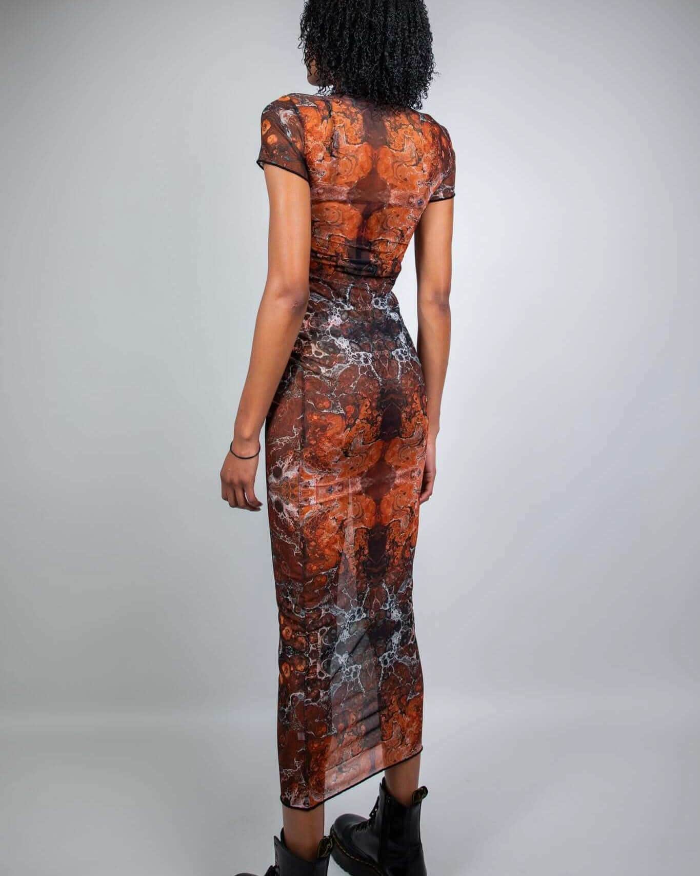 Back view of rave bodysuit style Fossil mesh maxi dress with orange marbled pattern for festival wear
