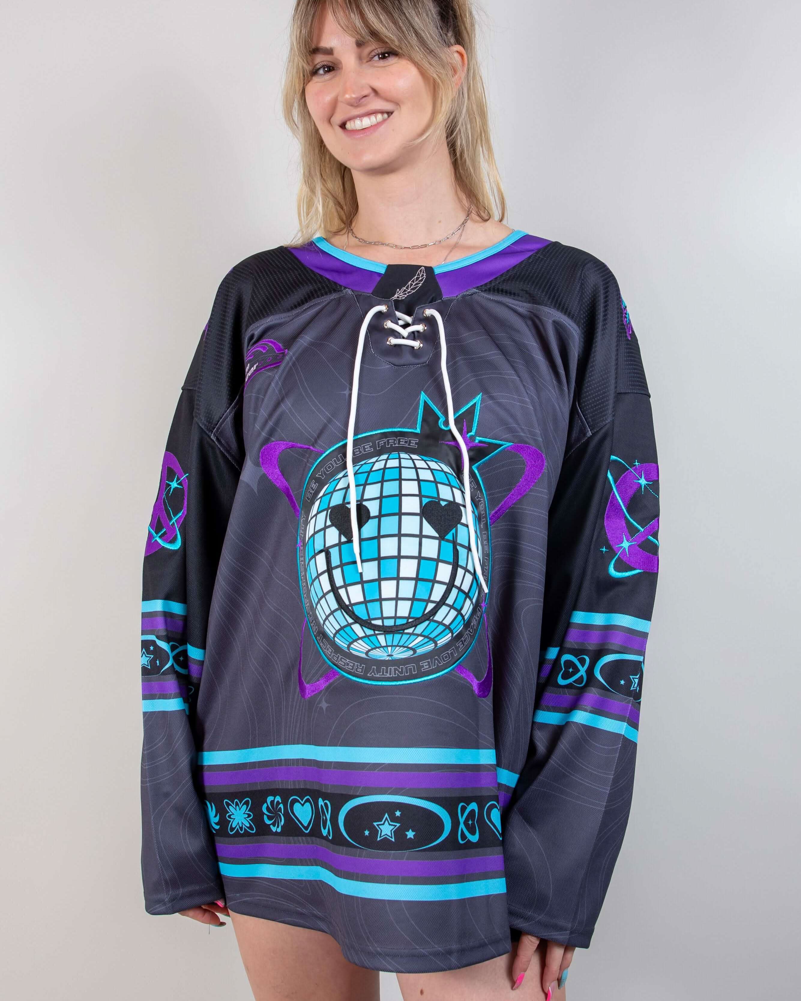 Woman modeling Freedom Fam hockey jersey rave bodysuit style in purple and teal front view