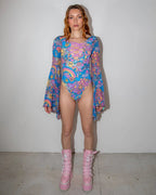 Groovy Goddess Bodysuit front view, featuring a vibrant psychedelic pattern with smiley faces and peace signs, perfect for rave festivals