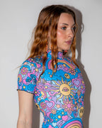 Groovy Wavy Baby Bodysuit from the side, showcasing the vibrant psychedelic pattern with smiley faces, mushrooms, and rainbows, perfect for a festival.
