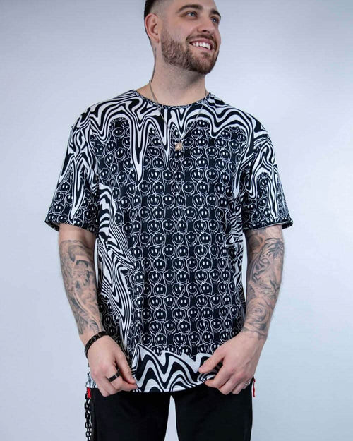 Rave bodysuit style Meltdown oversized tee with trippy black white pattern on tattooed festival model front view