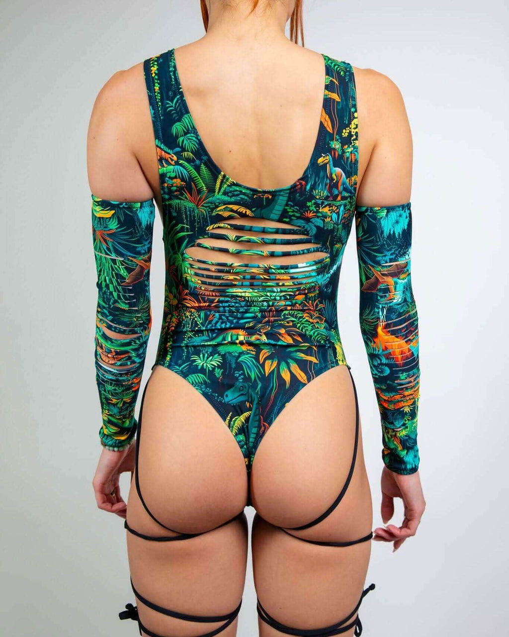 Back view of Mesozoic rave bodysuit with tropical print, cutout details and matching arm sleeves for festival wear