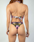 Back view of model wearing Monarch butterfly print rave bodysuit with colorful wing design and tie details
