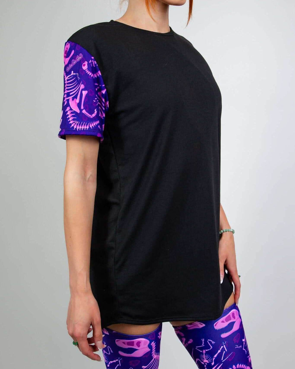 Purple dinosaur fossil rave bodysuit styled as black t-shirt with matching thigh-highs, festival outfit side view