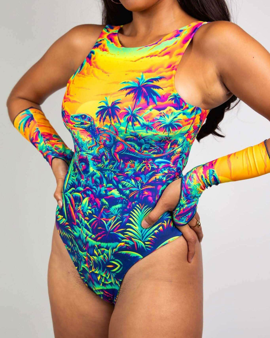Woman modeling Saurian tropical print rave bodysuit with matching arm sleeves in vibrant festival colors