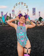 Woman wearing Sugar Rush rave bodysuit with psychedelic print at music festival with Ferris wheel background