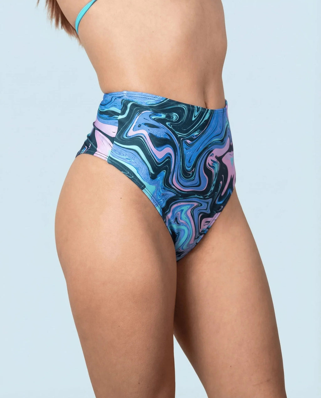 Side view of Glacial High Waisted Bikini Bottoms, featuring a unique swirling pattern of blue, teal, and lilac, perfect for rave festivals.