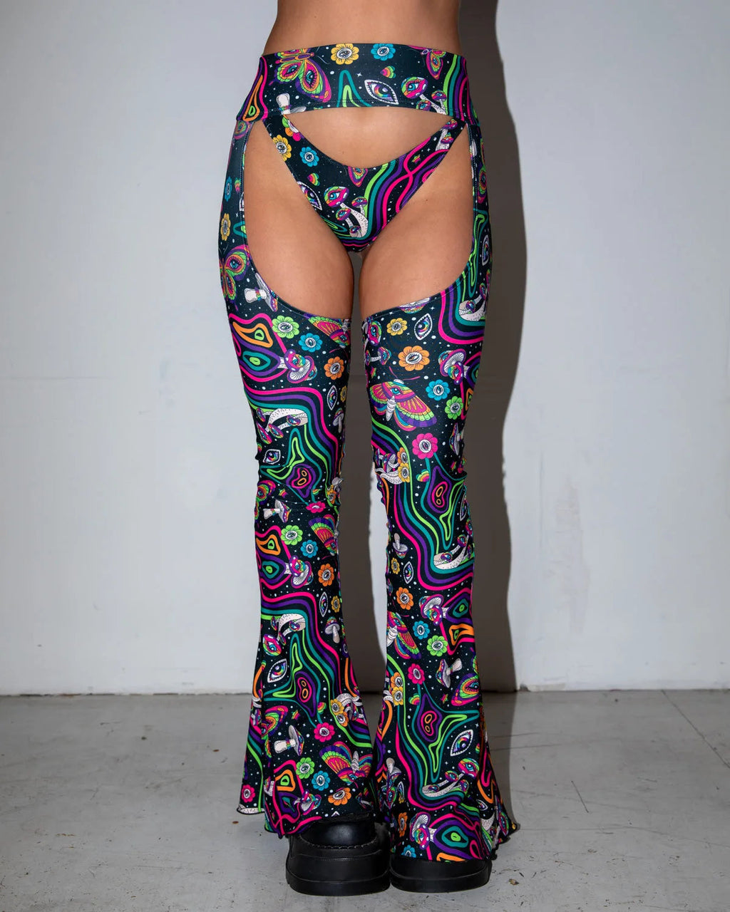 Awaken Bell Chaps front view, featuring a vibrant psychedelic pattern with mushrooms and eyes, perfect for rave festivals.