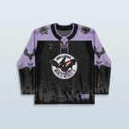 Front view of the Batshit Hockey Jersey, a limited edition rave top in lavender and black, featuring a cartoon bat crest and a haunted graveyard design.