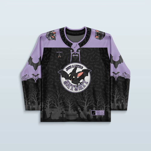 Front view of the Batshit Hockey Jersey, a limited edition rave top in lavender and black, featuring a cartoon bat crest and a haunted graveyard design.