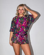 Awaken Mesh Oversized Tee front view, a vibrant psychedelic rave top with a black belt and silver chains.