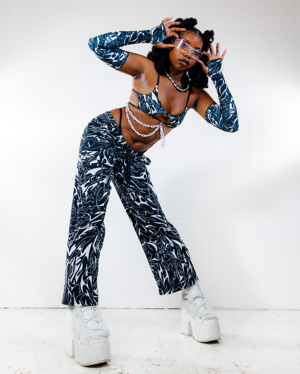 BLVDE Lucy Pants in black and white marble swirl print, worn by a model posing front for a rave festival.