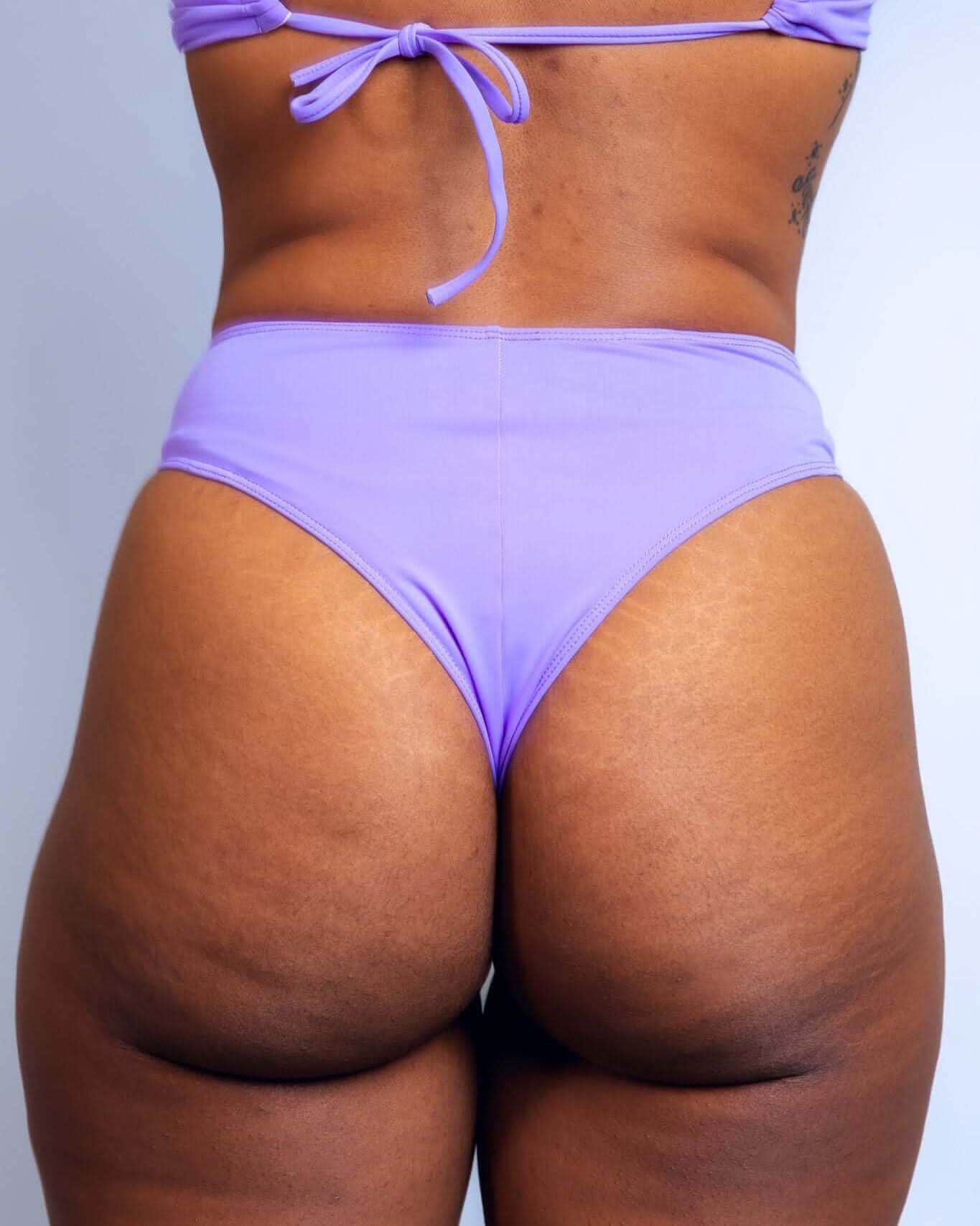 Back view of lavender high waisted thong rave pants with matching halter top on model
