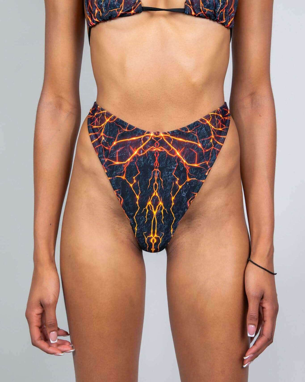 Magma retro thong rave pants with fiery lava print - black base with orange yellow veining front view